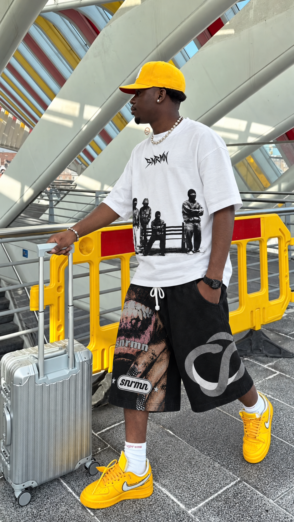 SNRMN white tee and graphic shorts yellow cap